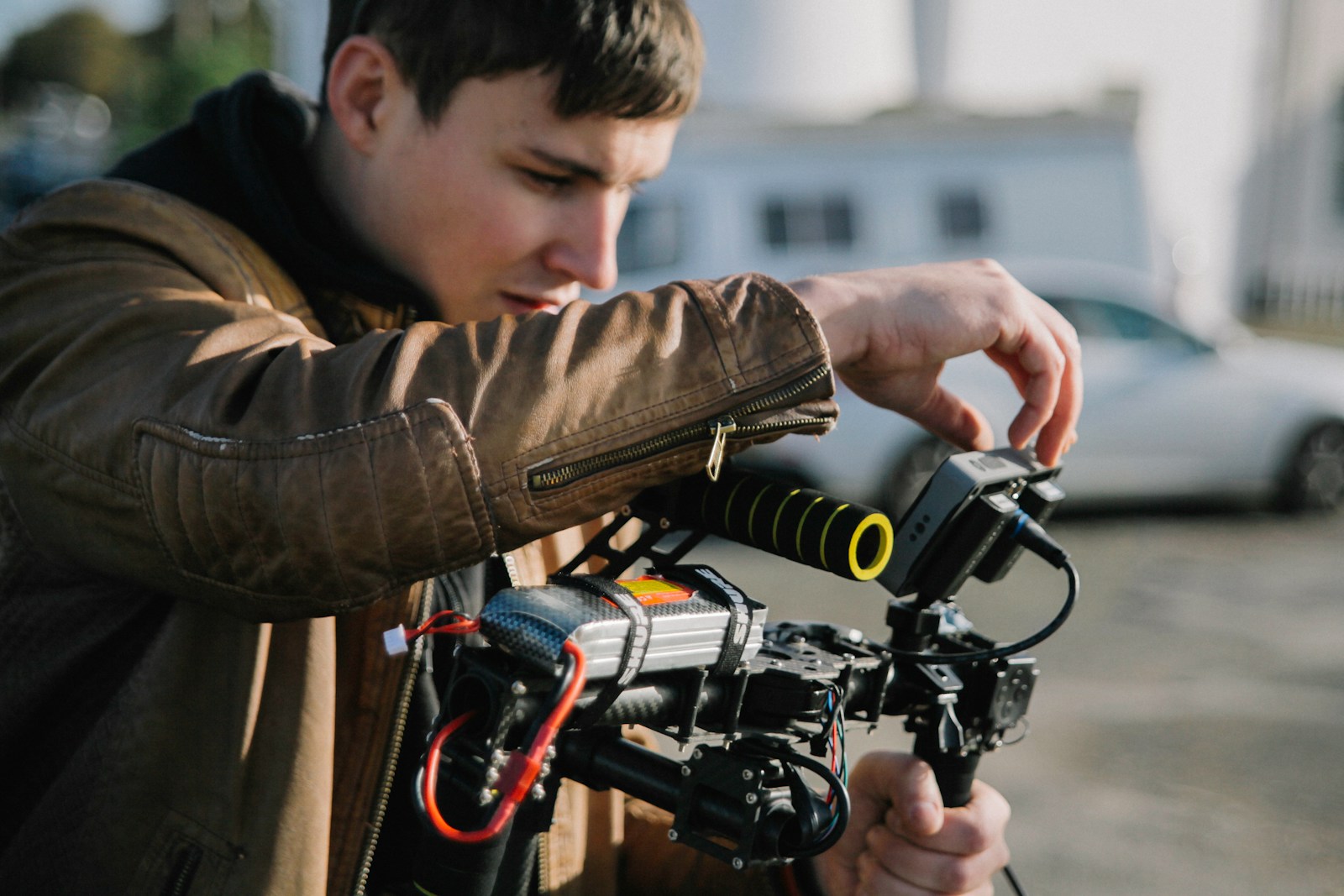 person operating black camera on gimbal at daytime